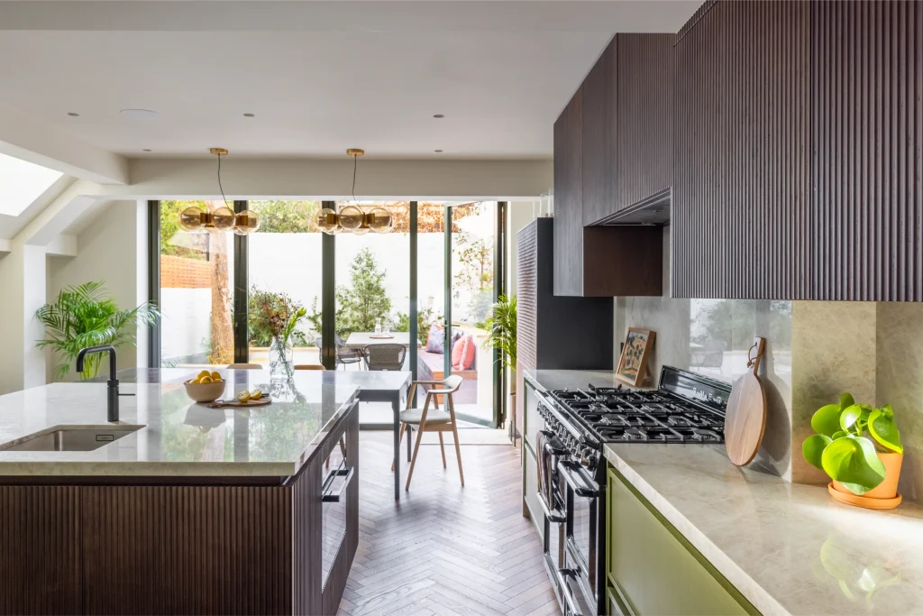 London kitchen in Hurlingham Park with island, modern cabinetry and open-plan garden view design
