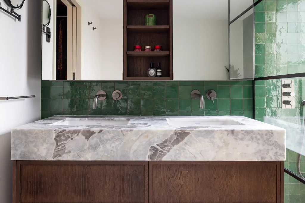 Modern London bathroom with marble countertop, green tiles and built-in storage design