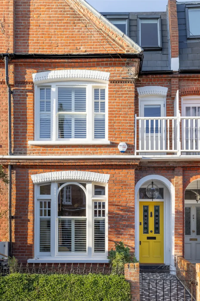 London house exterior in Hurlingham Park with brick facade, sash windows and yellow front door