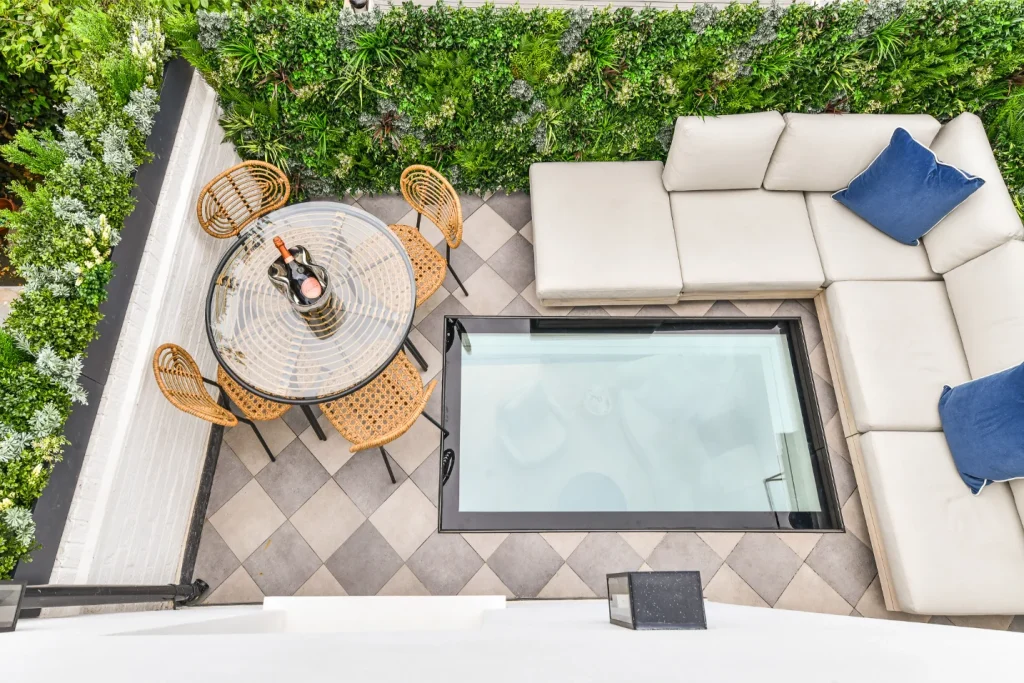 Kensington Place roof terrace: walk-on glass floor, living wall, checkerboard patio, and outdoor sofa