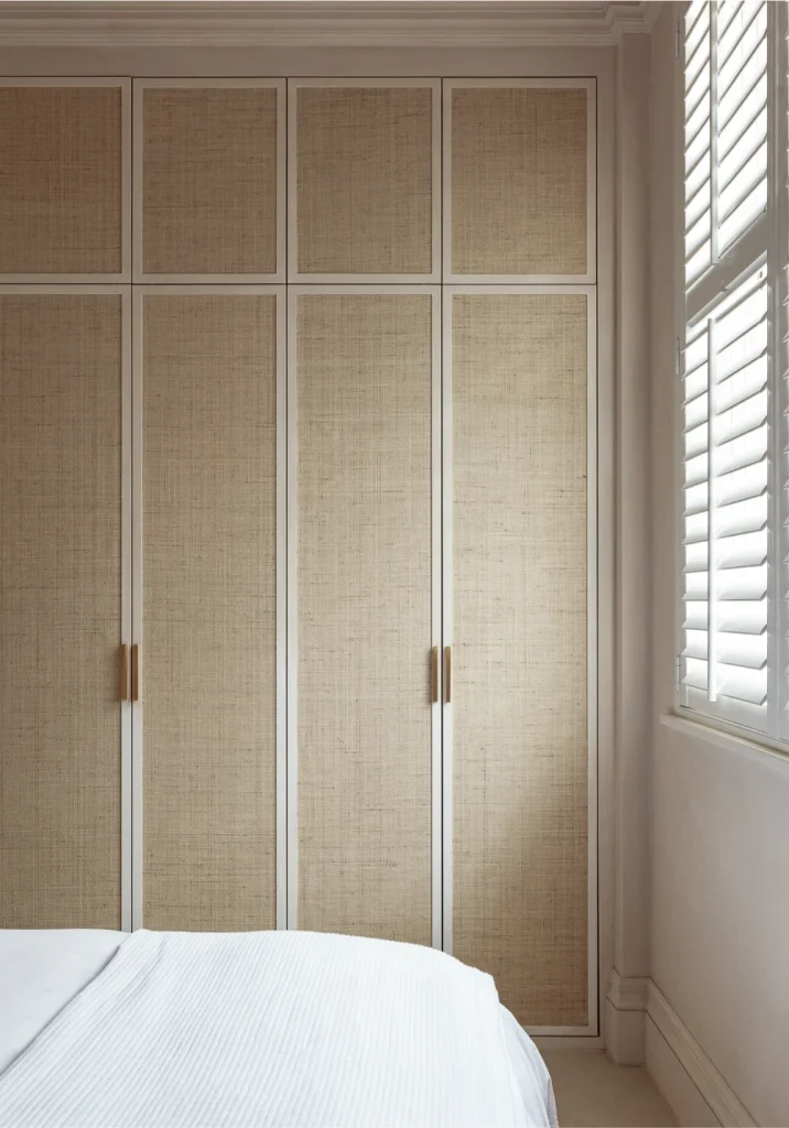 Modern Kensington interior: floor-to-ceiling custom wardrobes featuring raffia inserts and white shutters