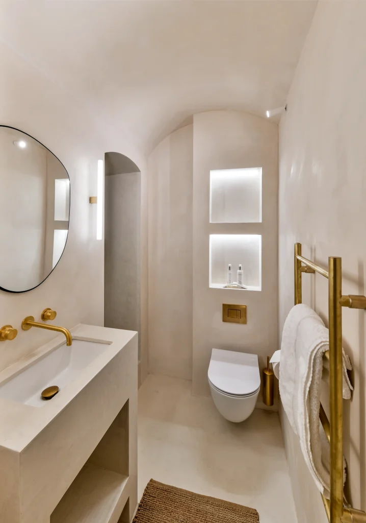 Modern Kensington bathroom: bespoke microcement sink, organic mirror, and gold heated towel rail