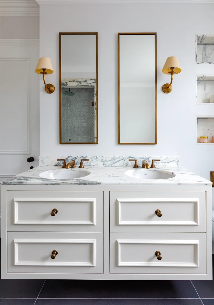 Modern Kensington bathroom: bespoke white double vanity with marble surface and brass wall sconces