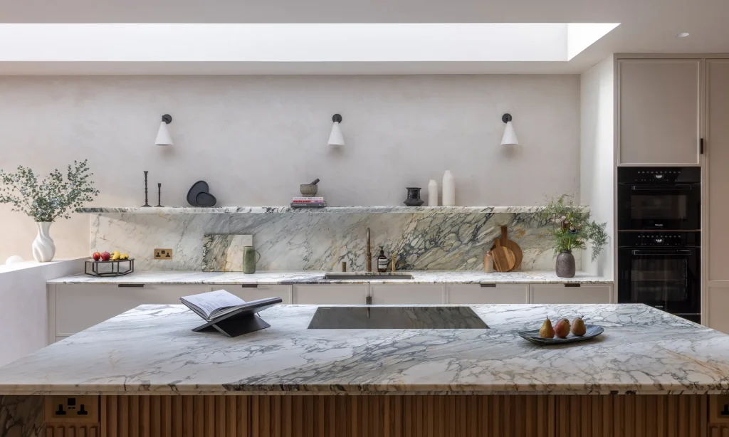 Bespoke kitchen design with sculptural marble island and fluted oak cabinetry by Project London