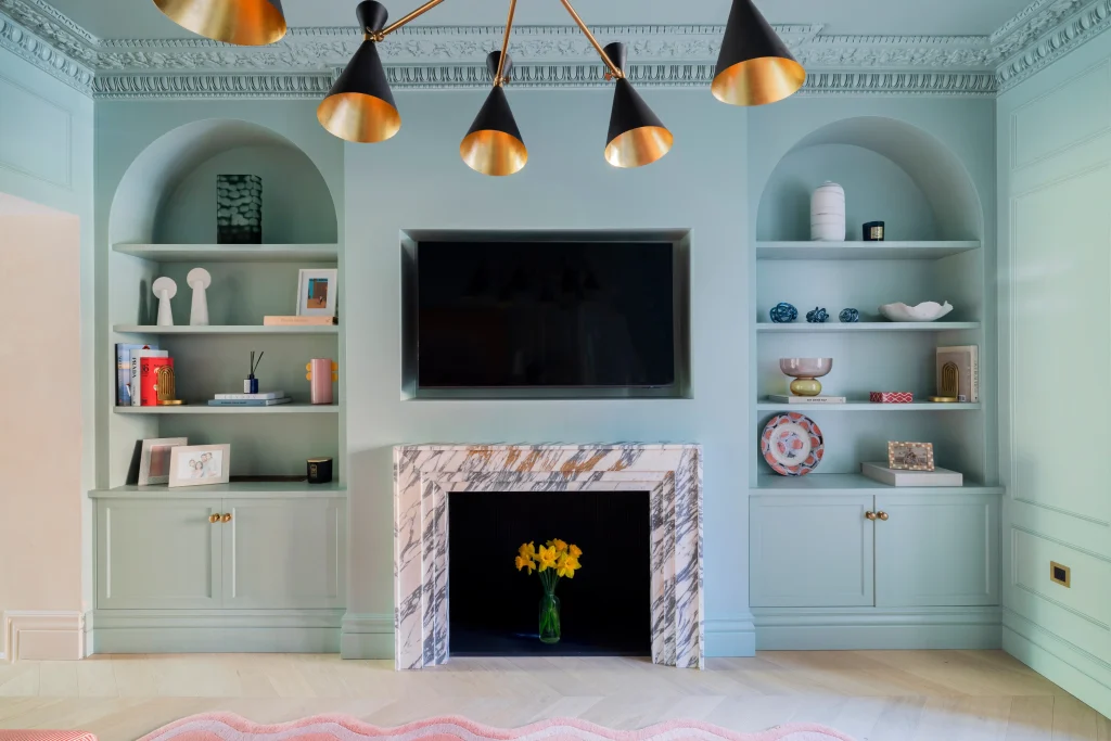 Luxury London living room with duck egg blue arched alcoves, marble fireplace, and brass lighting by Project London