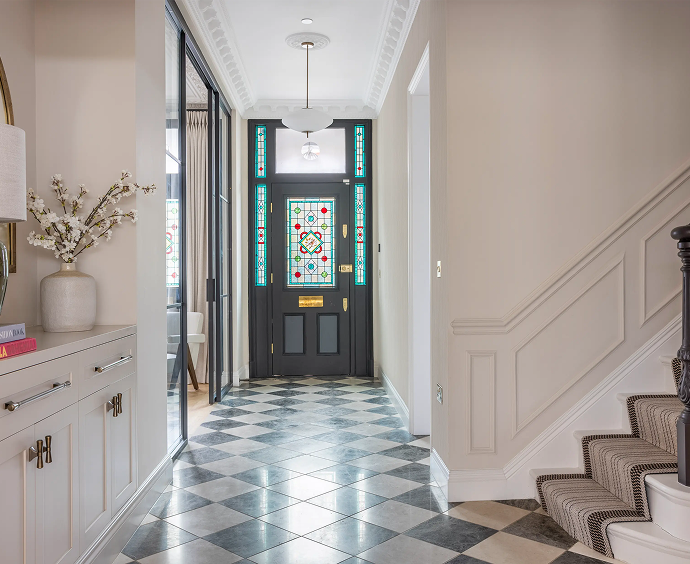 Luxury London hallway interior with custom cabinetry, tiled flooring and traditional stained glass entrance door
