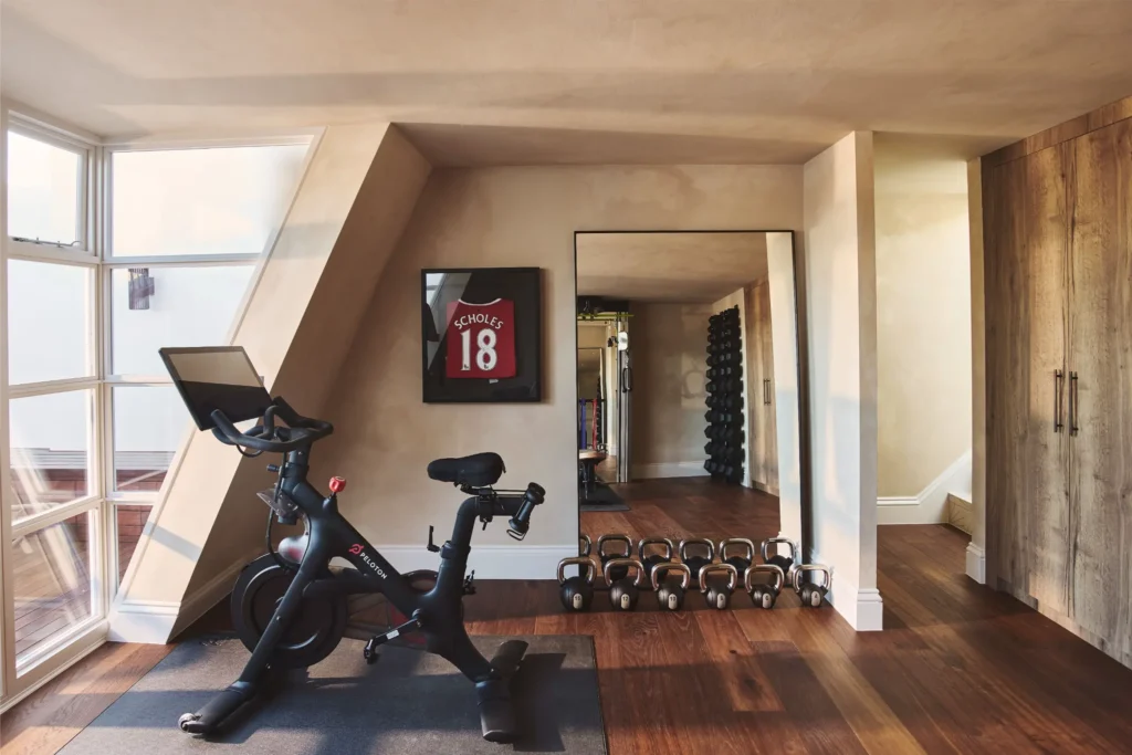 Luxury home gym in Portobello Road London with stationary bike, weights and natural light interior