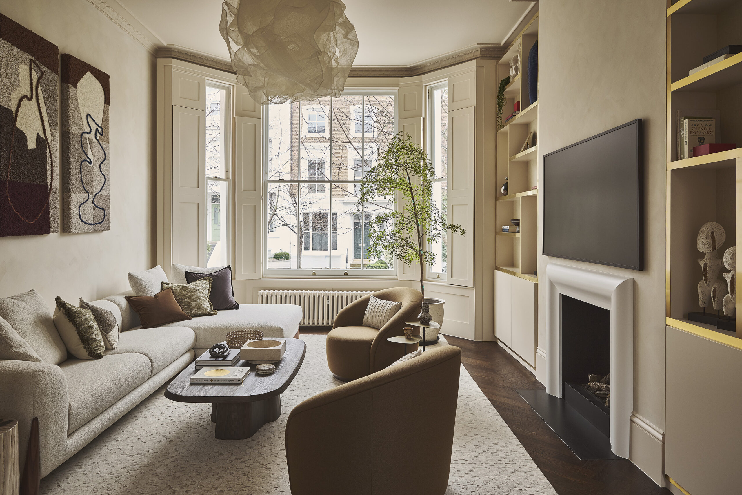 Luxury London living room featuring an integrated TV wall, white window shutters, and microcement walls