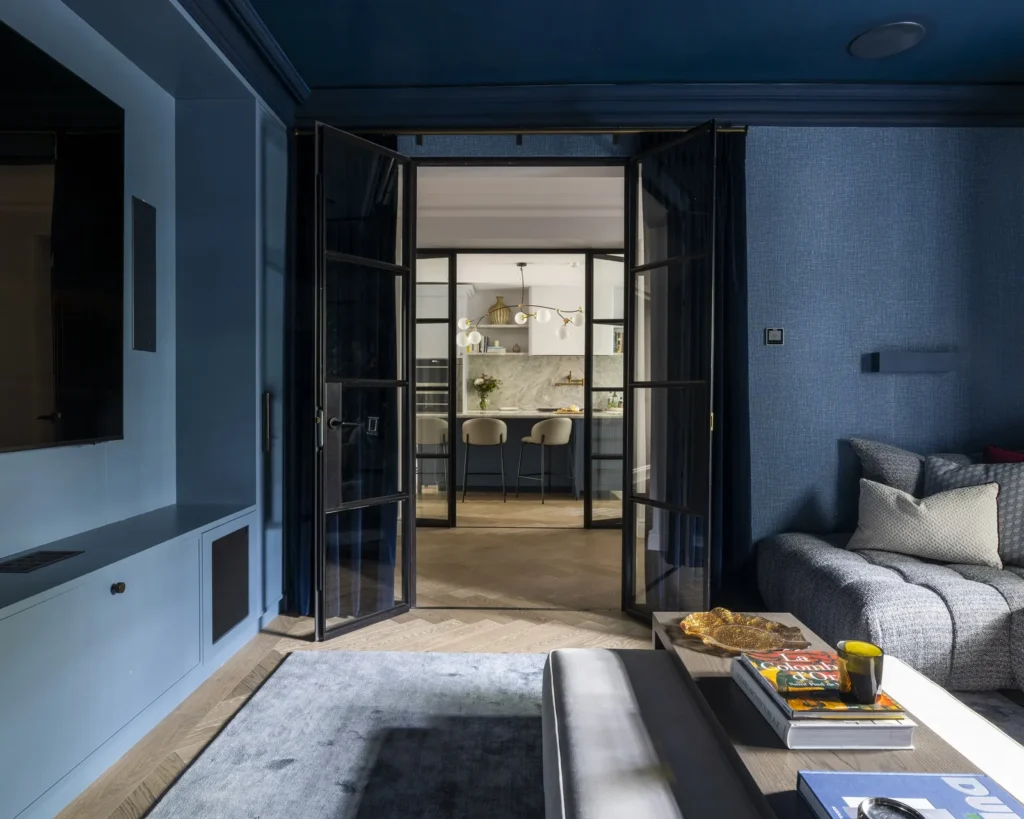 Modern home cinema room by Project London featuring textured blue wallpaper and black glass partitions