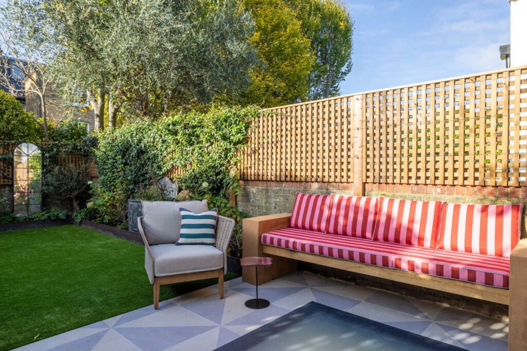 Modern Bradbourne courtyard: custom garden seating, outdoor armchair, lawn, and architectural roof light
