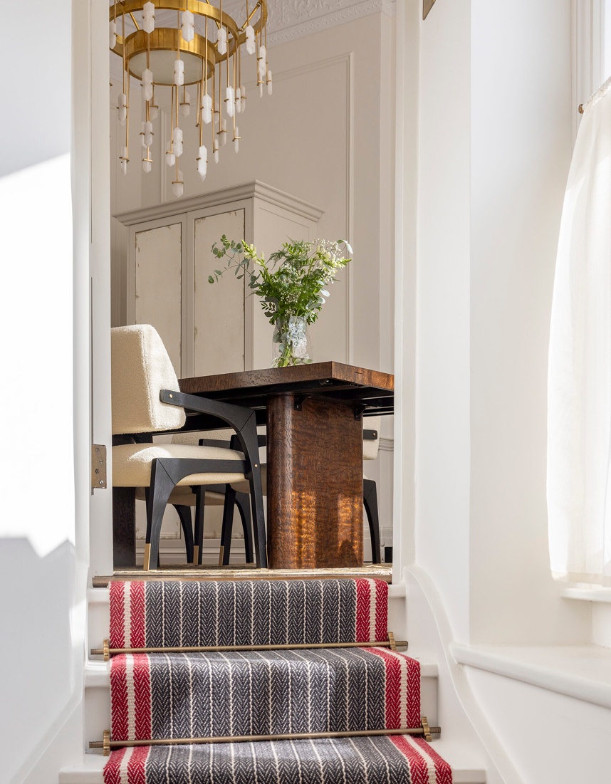 Elegant London home interior featuring staircase runner, dining table and bespoke cabinetry